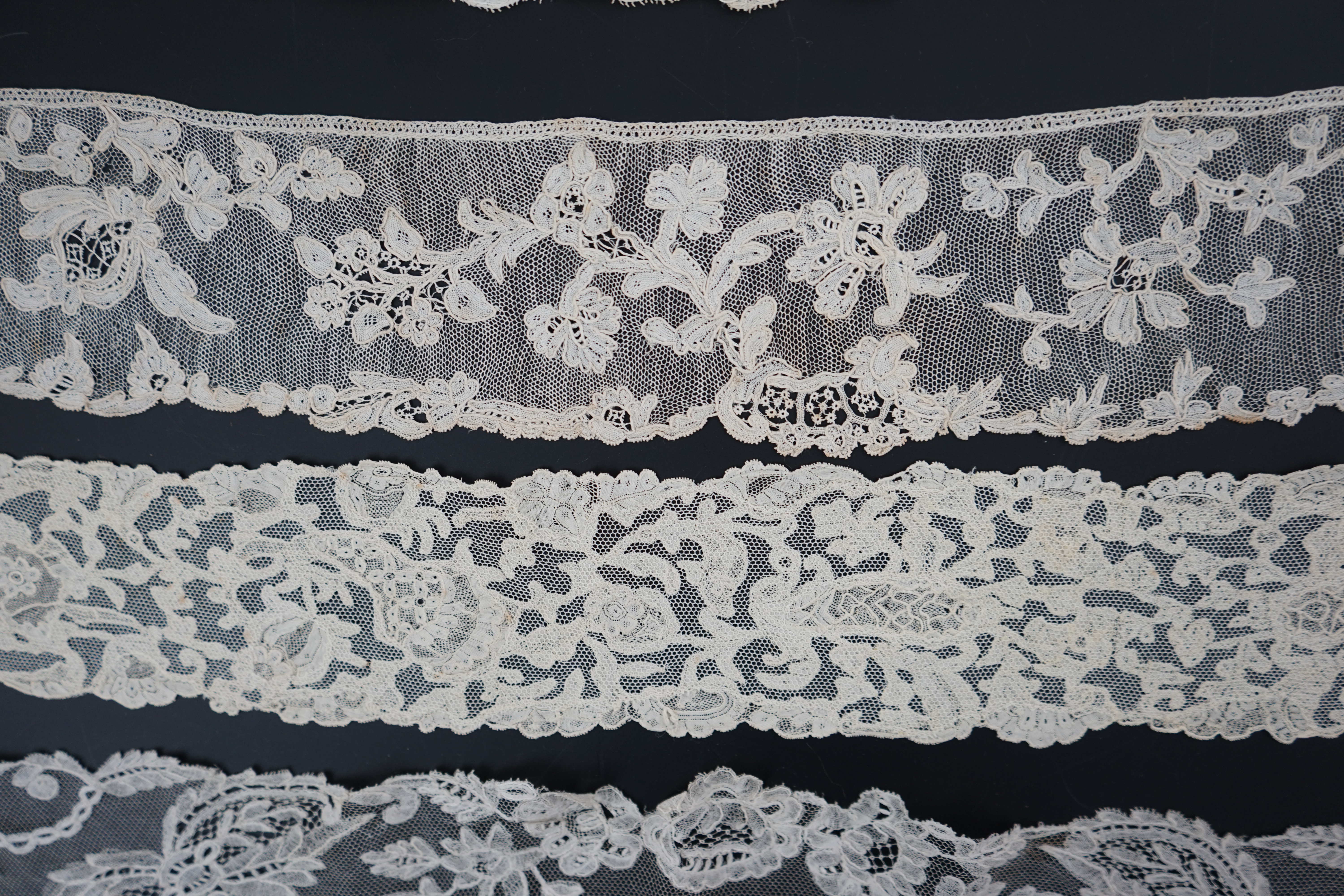 A large section of an ornate 19th century Brussels bobbin lace wedding veil, with two finished edges and one cut edge together with 18th century and later needle lace, an Argentan and an Alencon trimming, possibly an 18t